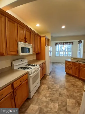 a kitchen with stainless steel appliances a stove a sink a microwave a refrigerator and cabinets