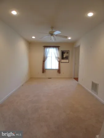 an empty room with a window and a ceiling fan