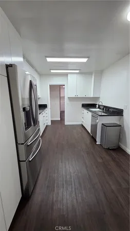 a kitchen with granite countertop a sink stove and cabinets