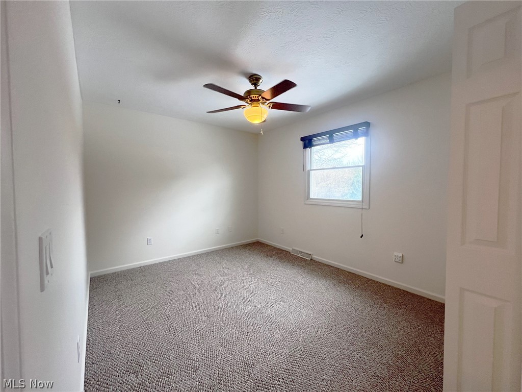 5203 Ridgeland Street Lorain, OH 44055 - Photo 9 of 39 Empty room featuring dark colored carpet and ceiling fan