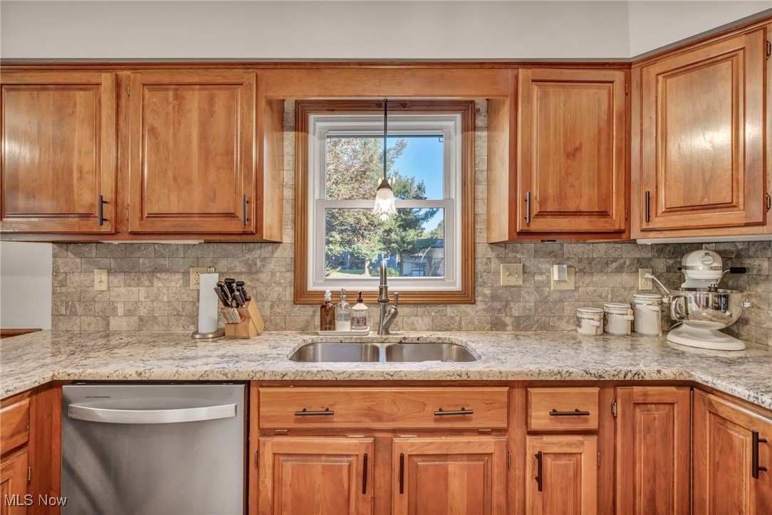300 Decourcey Rittman, OH 44270 - Photo 21 of 48 Kitchen featuring solid wood cabinetry, granite countertops and a marble backsplash, healthy amount of natural light, and stainless appliances
