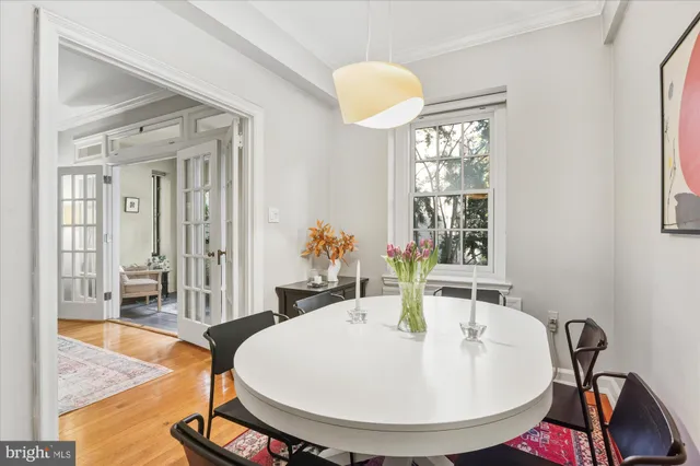 a kitchen with stainless steel appliances a refrigerator a sink a stove and white cabinets with wooden floor