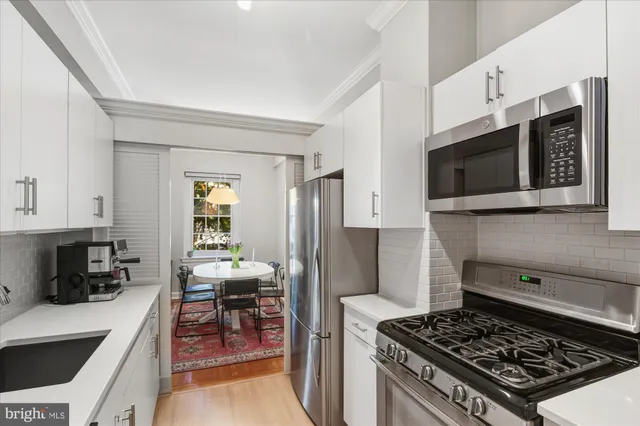 a kitchen with a sink cabinets and wooden floor