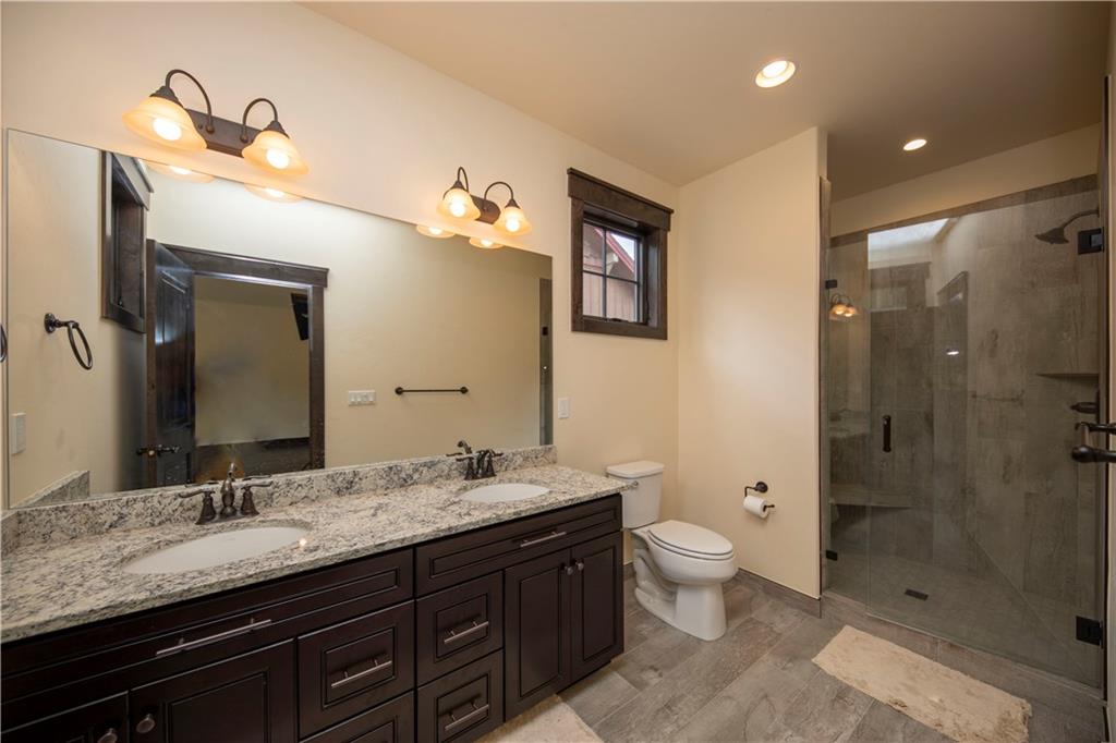 687 Independence Road Keystone, CO 80435 - Photo 15 of 26 a bathroom with a granite countertop sink a toilet a shower and a mirror