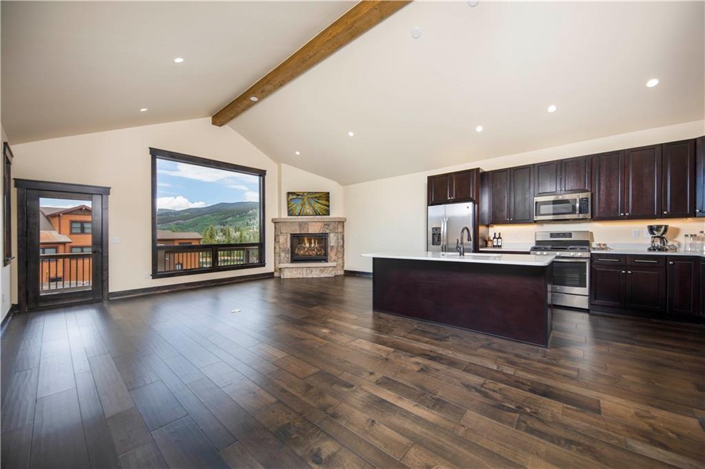 687 Independence Road Keystone, CO 80435 - Photo 3 of 26 a kitchen with stainless steel appliances granite countertop a stove top oven a sink with wooden floors and cabinets