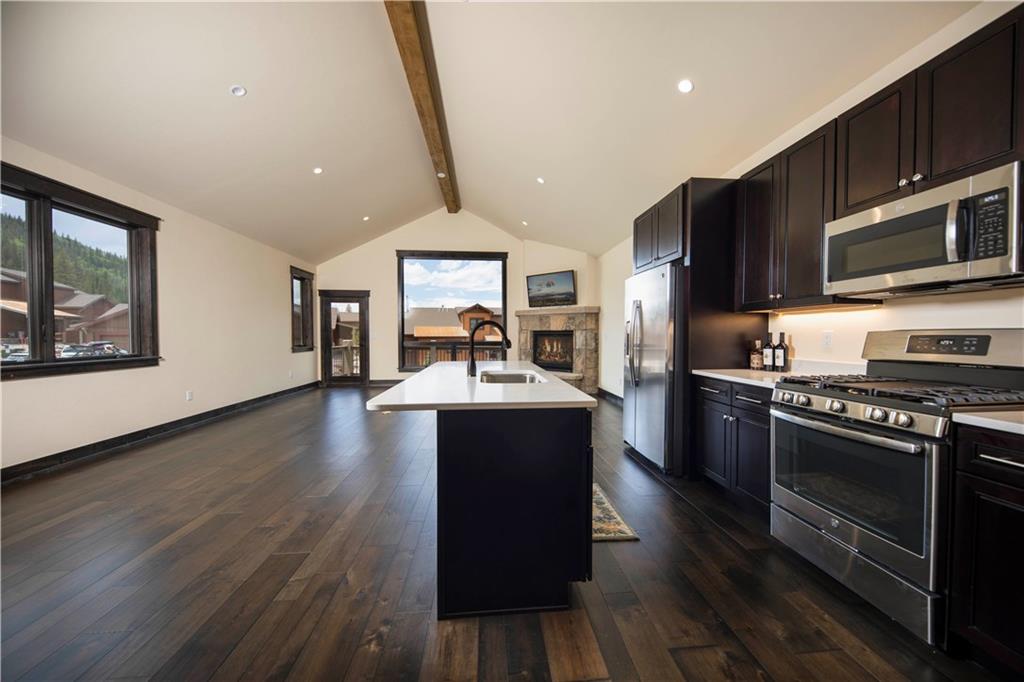 687 Independence Road Keystone, CO 80435 - Photo 4 of 26 a kitchen with stainless steel appliances granite countertop a stove a sink dishwasher and a microwave oven with wooden floor