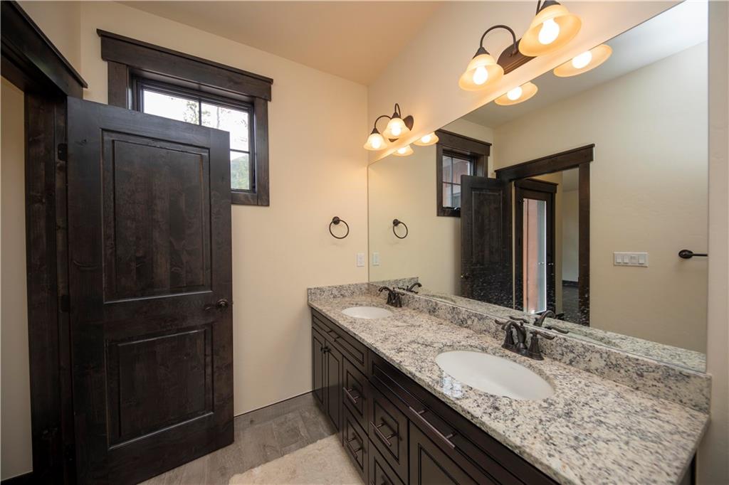 687 Independence Road Keystone, CO 80435 - Photo 9 of 26 a bathroom with a granite countertop sink a light fixture and a mirror