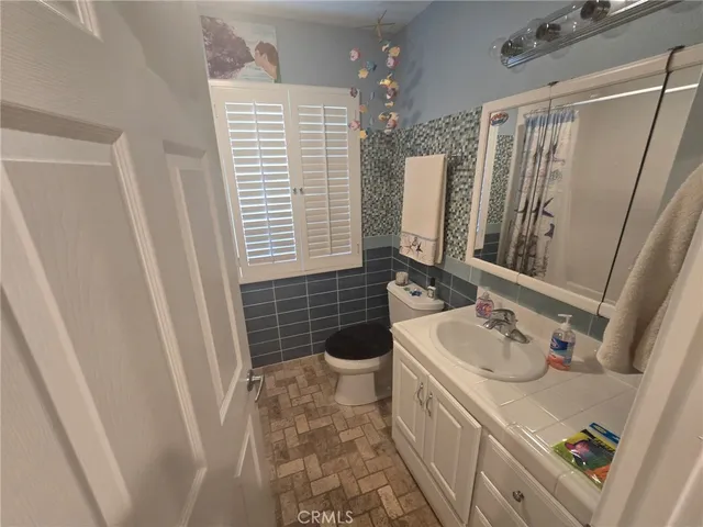 a bathroom with a sink a toilet and a mirror