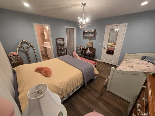 a bed room with a bed mirror and a chandelier