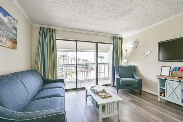 a living room with furniture a flat screen tv and a floor to ceiling window