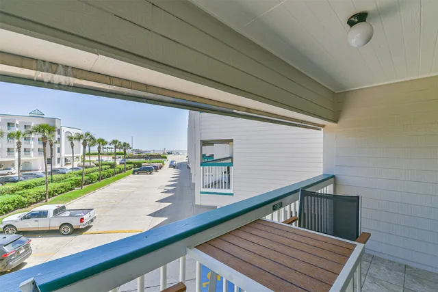 a view of a balcony with wooden floor and iron stairs