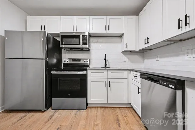 a kitchen with a refrigerator sink and cabinets