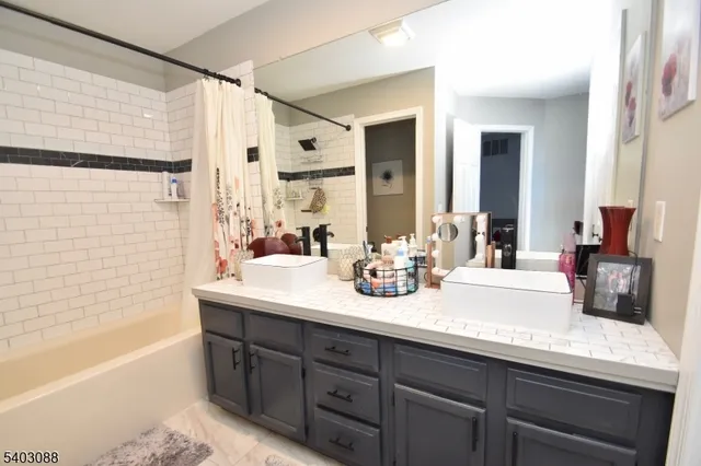 a bathroom with a tub sink and mirror