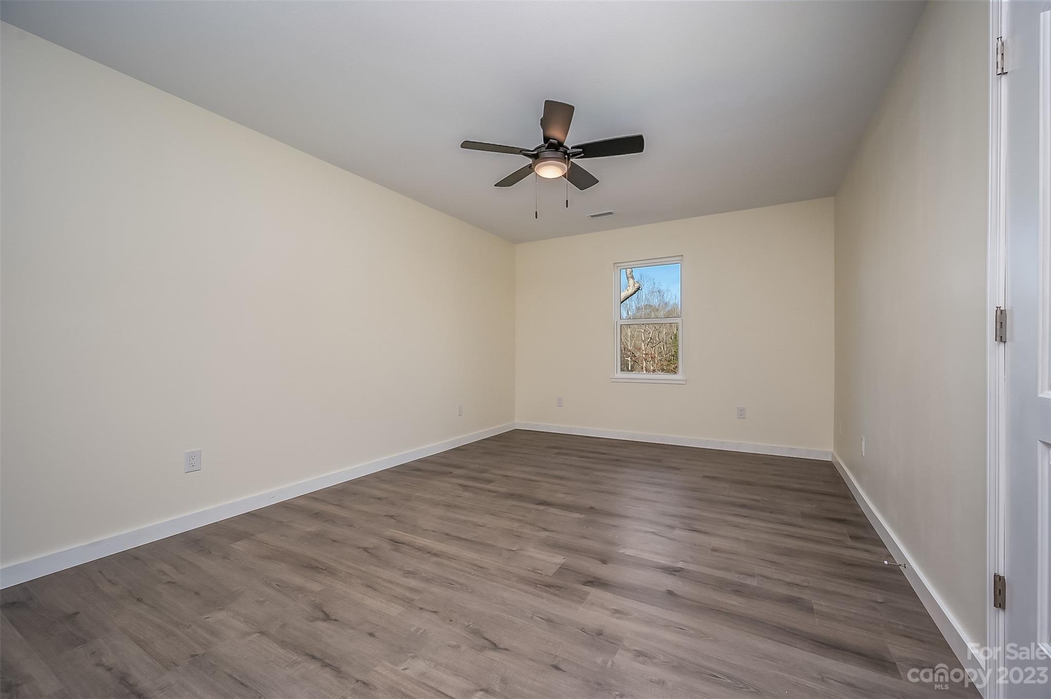 306 Observation Ridge Rutherfordton, NC 28139 - Photo 15 of 36 an empty room with wooden floor ceiling fan and windows