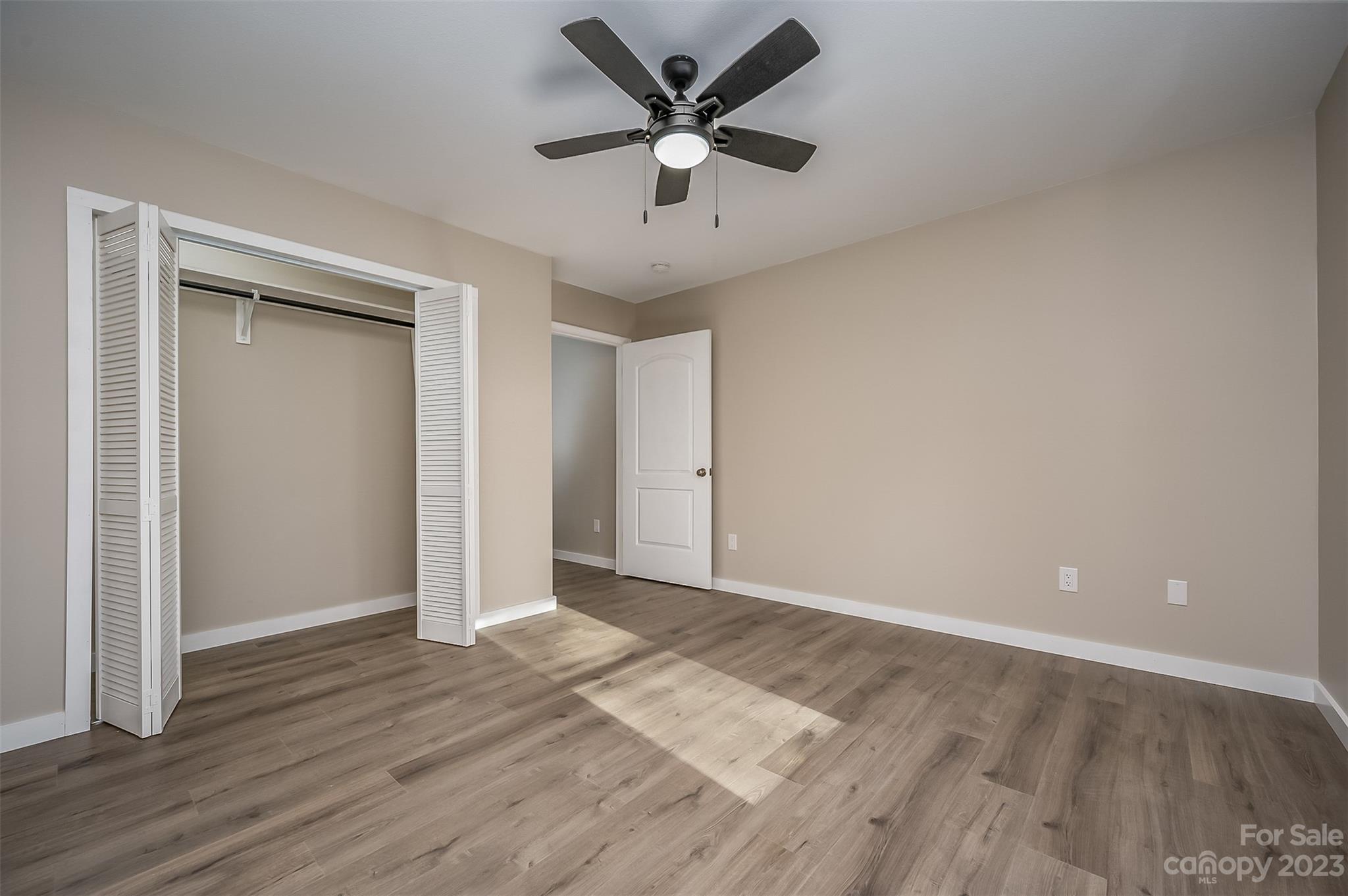 306 Observation Ridge Rutherfordton, NC 28139 - Photo 23 of 36 an empty room with wooden floor and a ceiling fan