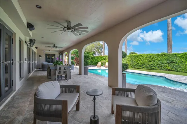 a view of a swimming pool with a lounge chair and palm trees