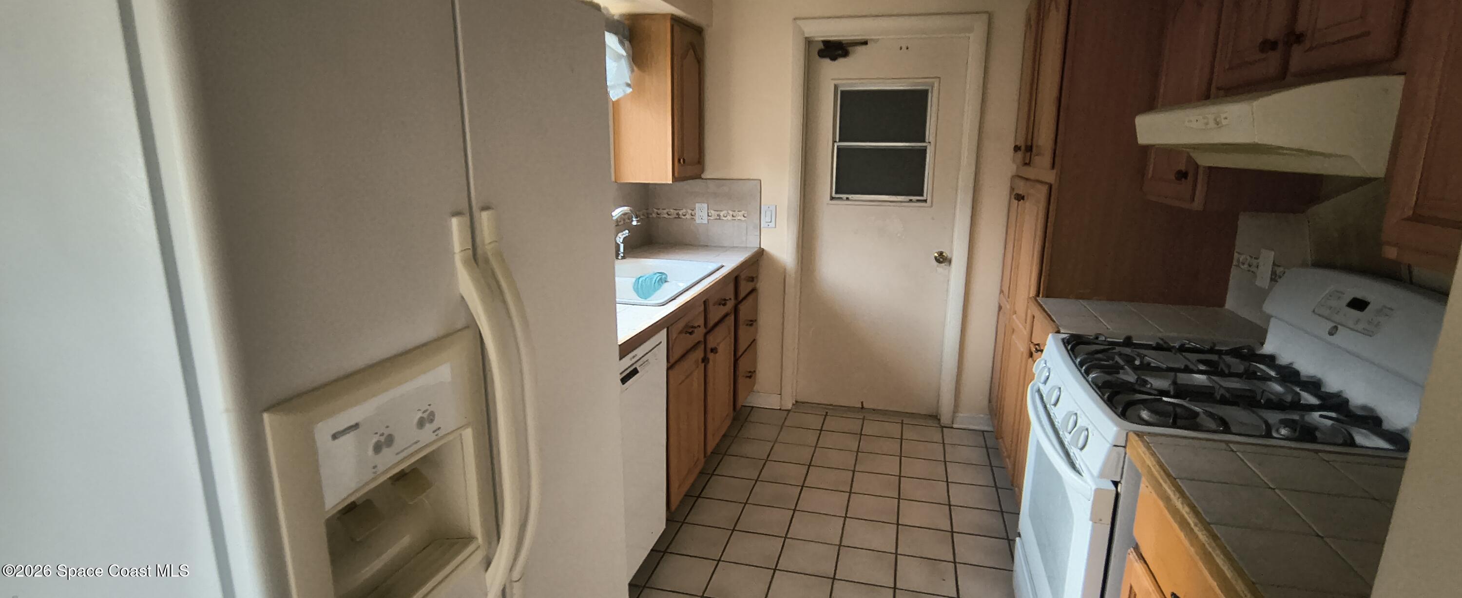 801 Espanola Way Melbourne, FL 32901 - Photo 11 of 18 a kitchen with a stove and a refrigerator