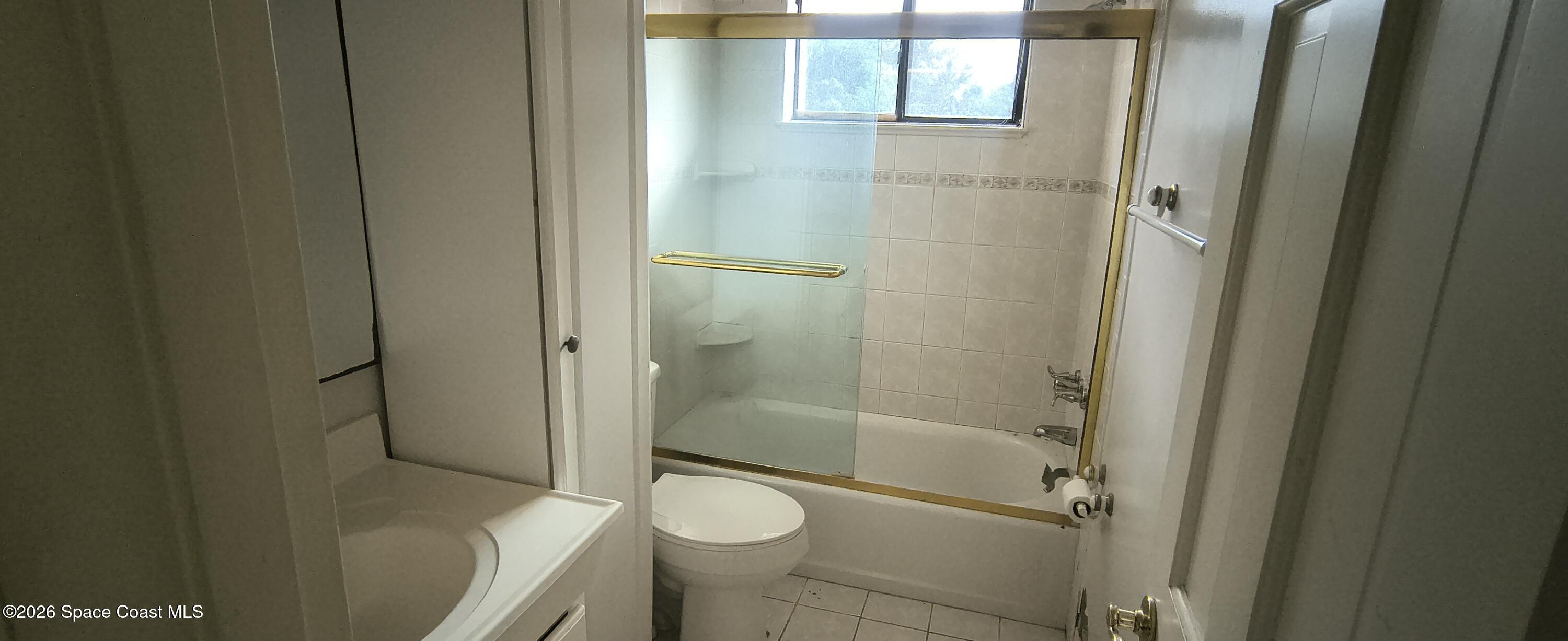 801 Espanola Way Melbourne, FL 32901 - Photo 16 of 18 a bathroom with a granite countertop toilet and a shower