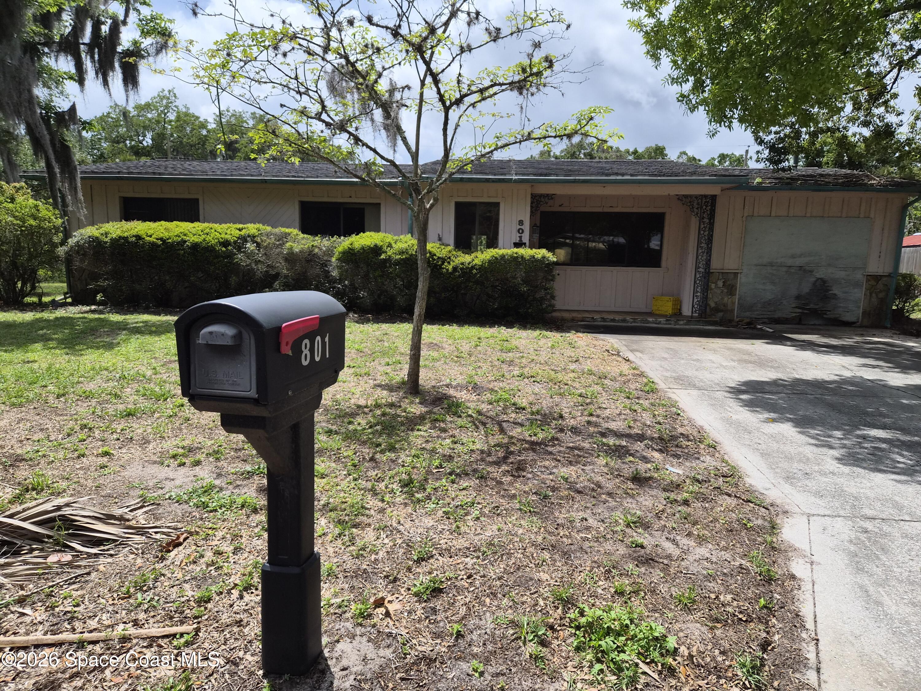 801 Espanola Way Melbourne, FL 32901 - Photo 2 of 18 a front view of a house with a yard and garage