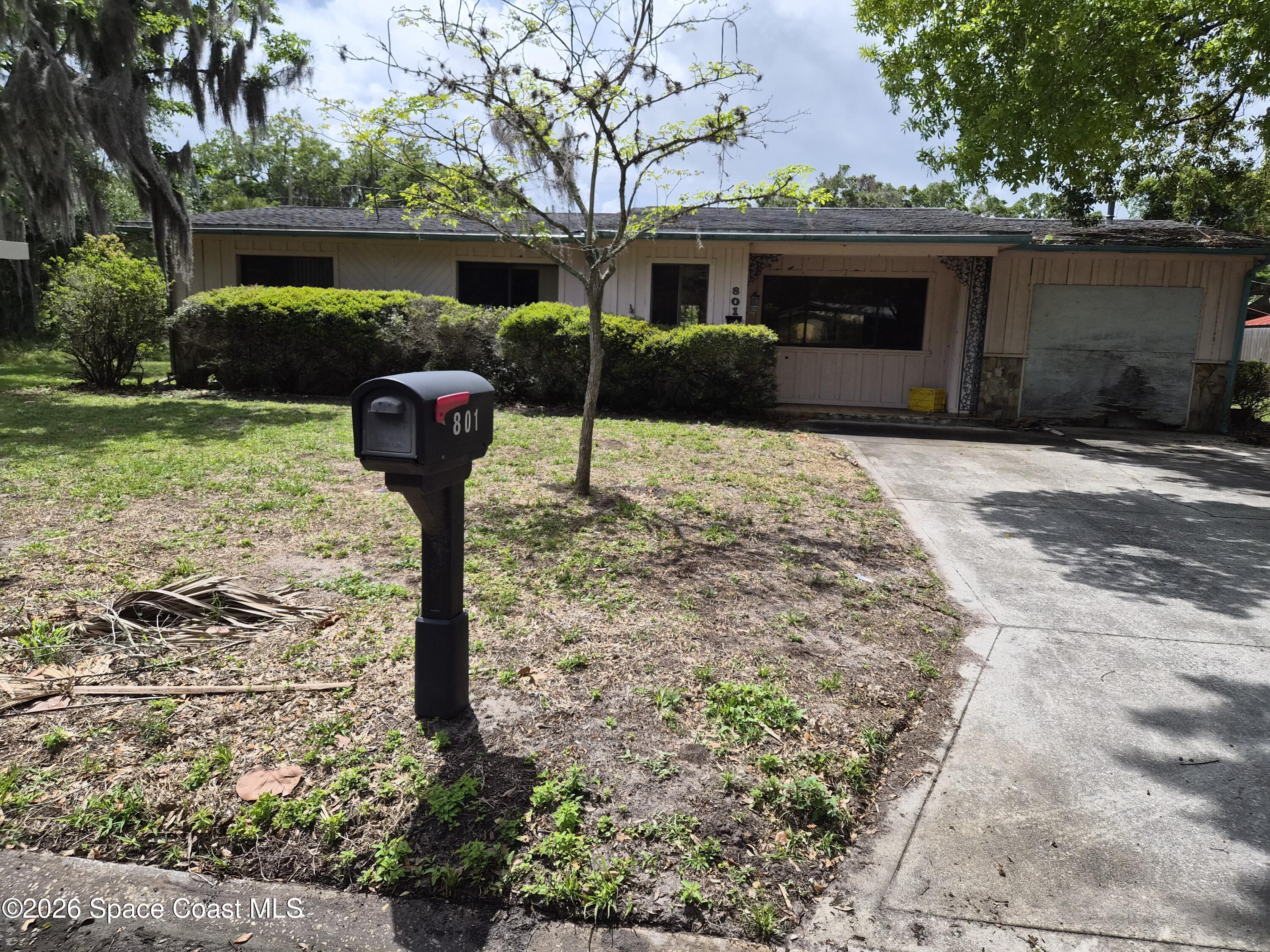 801 Espanola Way Melbourne, FL 32901 - Photo 3 of 18 a front view of a house with a yard and garage