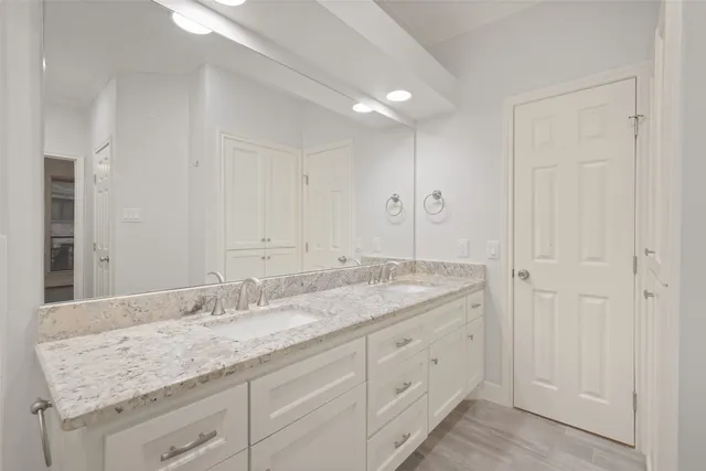 a bathroom with a granite countertop sink and a mirror