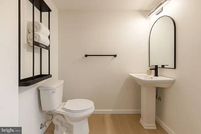 a bathroom with a sink a toilet and mirror