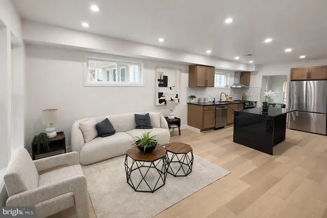 a living room with furniture kitchen view and a refrigerator