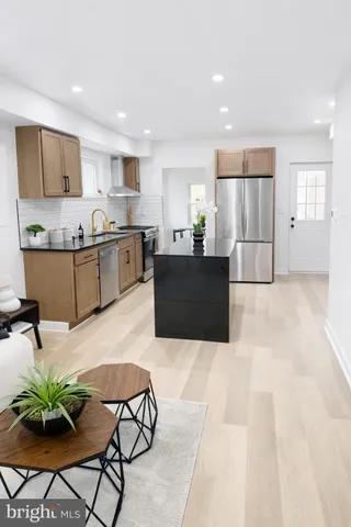 a large white kitchen with stainless steel appliances kitchen island granite countertop a sink and cabinets