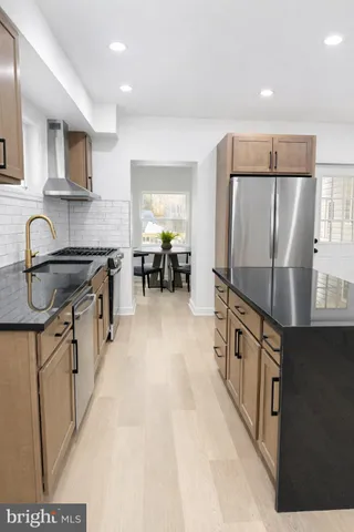 a kitchen with granite countertop a refrigerator stove top oven and sink