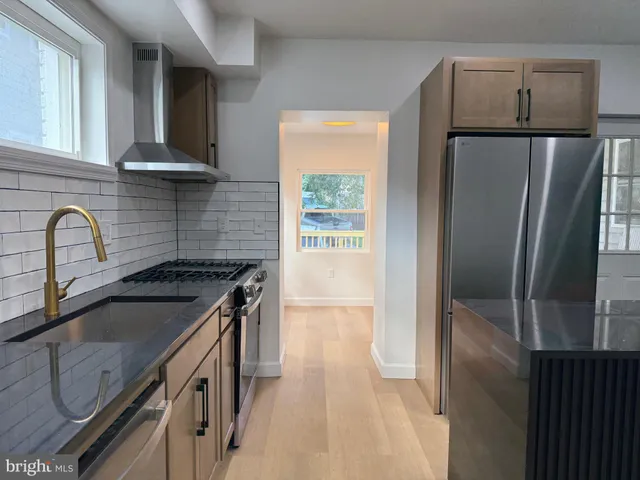 a kitchen with granite countertop a refrigerator and a sink