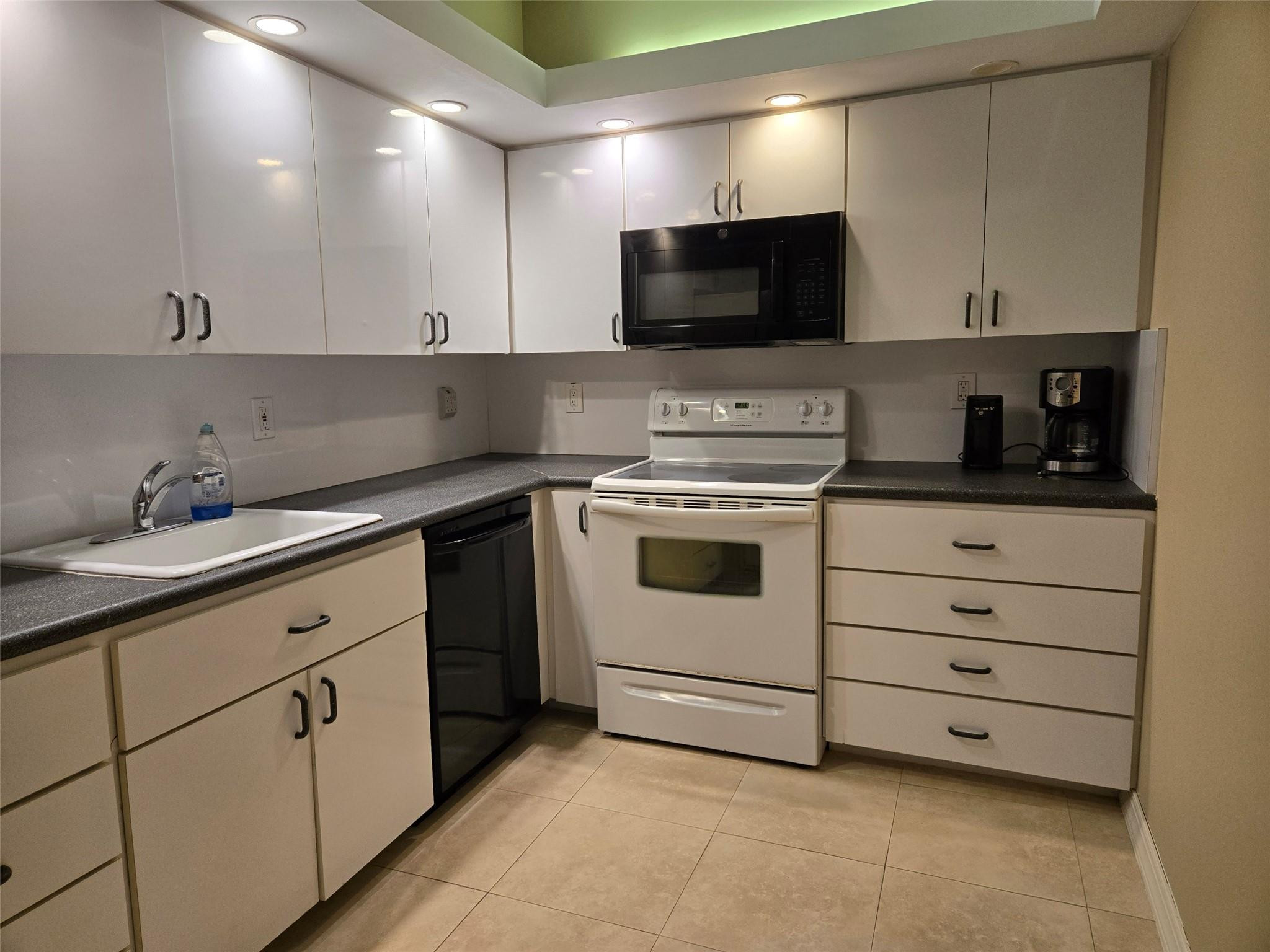 2851 South Ocean Boulevard, Unit 6D Boca Raton, FL 33432 - Photo 11 of 34 a kitchen with white cabinets and white appliances