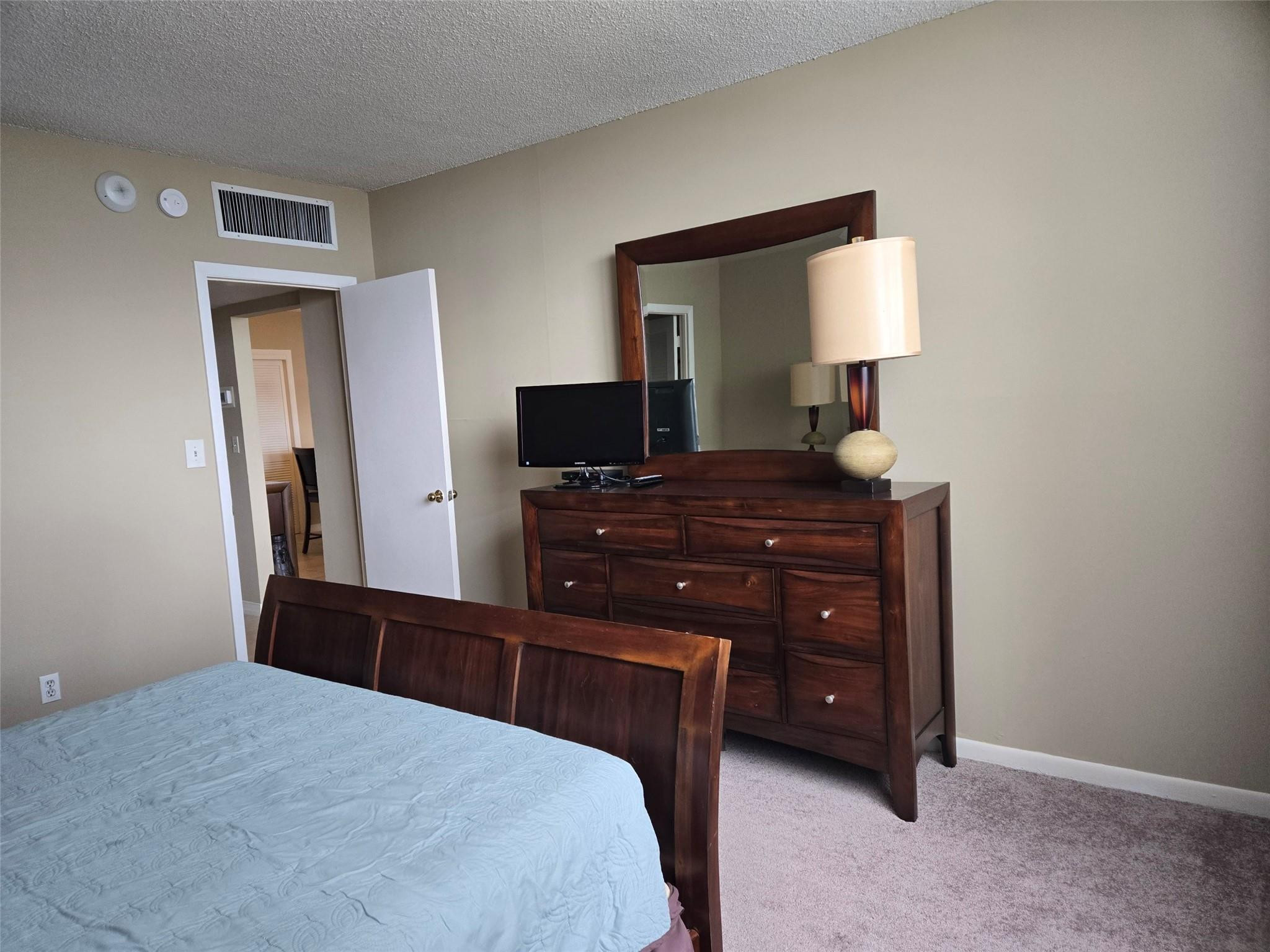 2851 South Ocean Boulevard, Unit 6D Boca Raton, FL 33432 - Photo 19 of 34 a bedroom with a bed and a flat tv screen on dresser