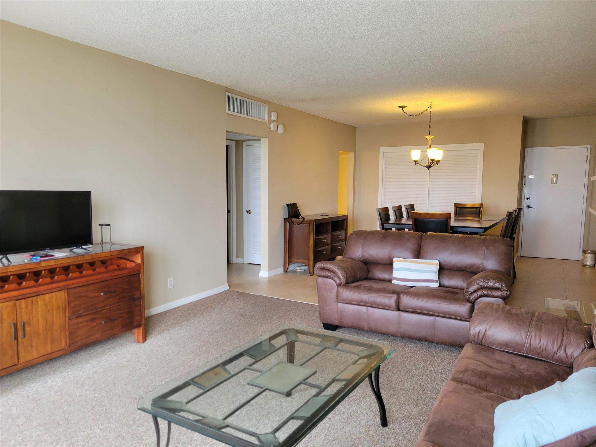 2851 South Ocean Boulevard, Unit 6D Boca Raton, FL 33432 - Photo 3 of 34 a living room with furniture and a flat screen tv