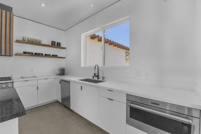 a kitchen with granite countertop a sink a stove and a microwave