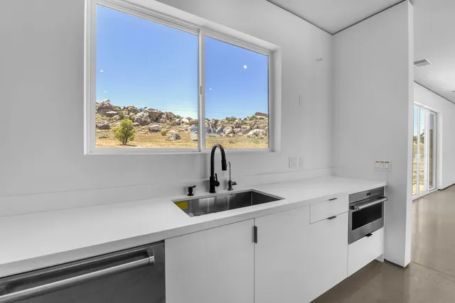 a kitchen with stainless steel appliances granite countertop a sink a refrigerator and a granite counter tops