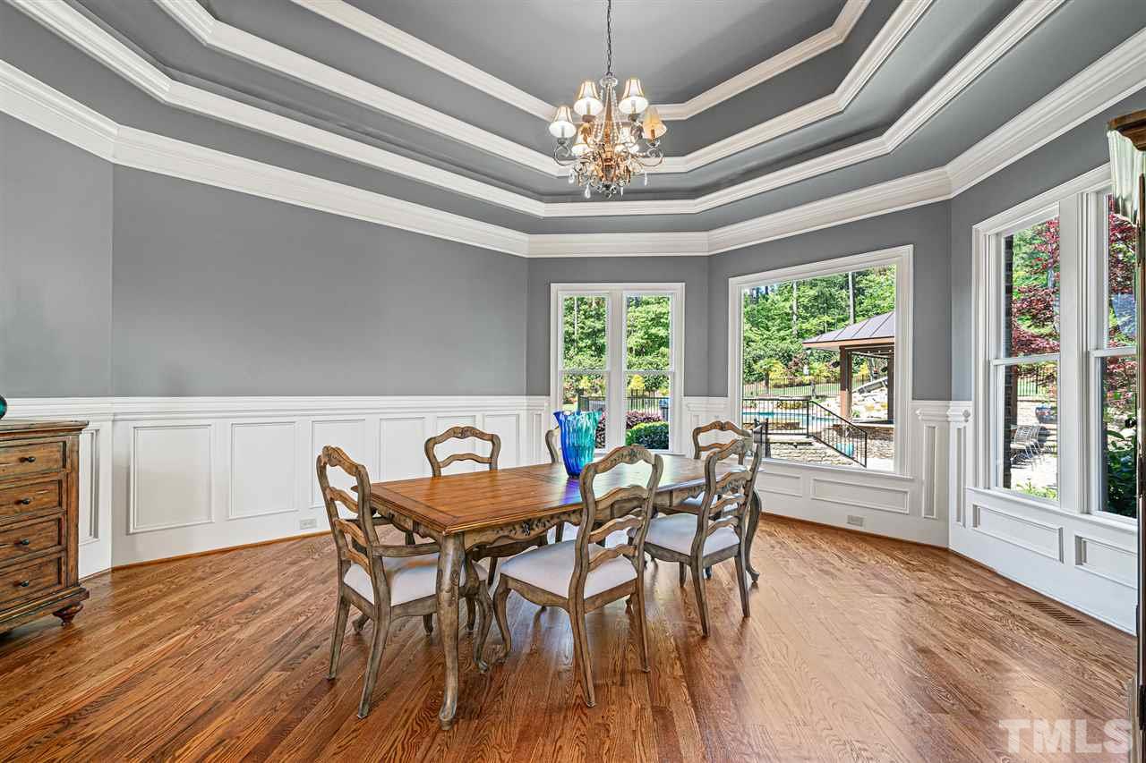 12515 Tuscan Lake Road Raleigh, NC 27613 - Photo 14 of 30 a dining room with furniture a chandelier and wooden floor