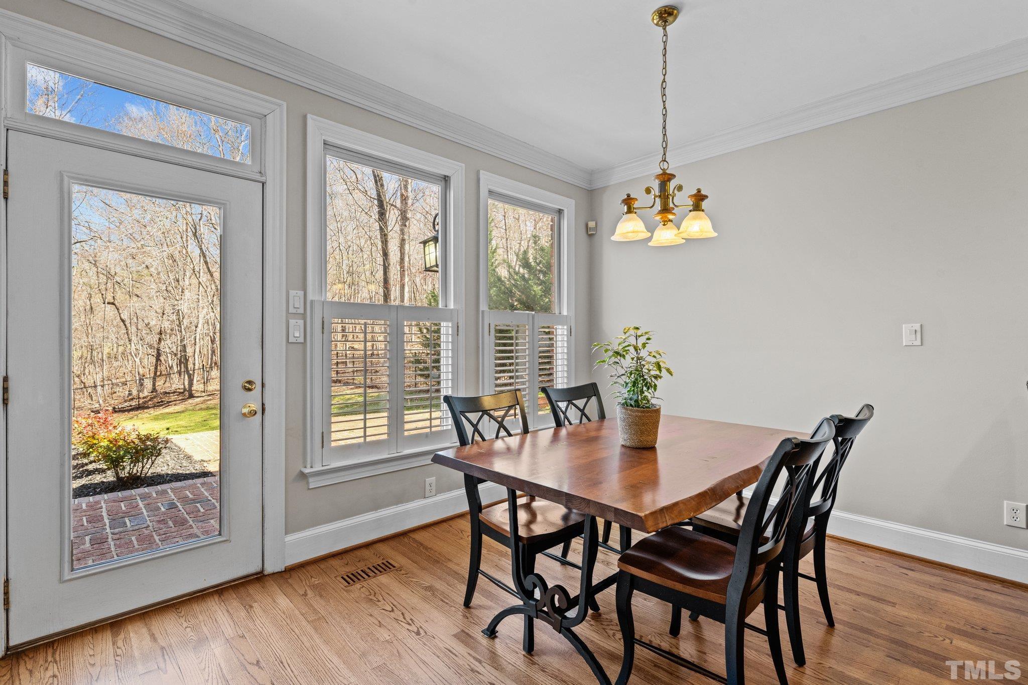 1112 Wagon Ridge Road Raleigh, NC 27614 - Photo 15 of 54 a dining room with furniture wooden floor a potted plant and a chandelier