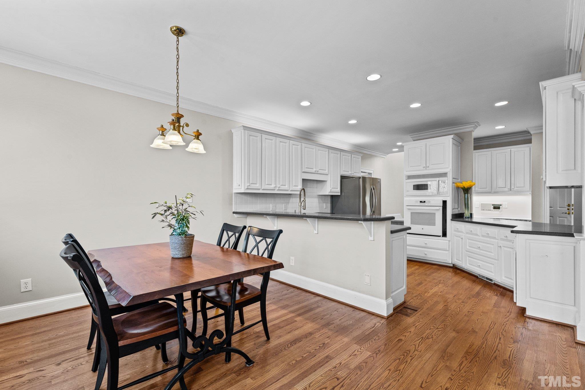 1112 Wagon Ridge Road Raleigh, NC 27614 - Photo 16 of 54 a view of a dining room and livingroom with furniture wooden floor a chandelier