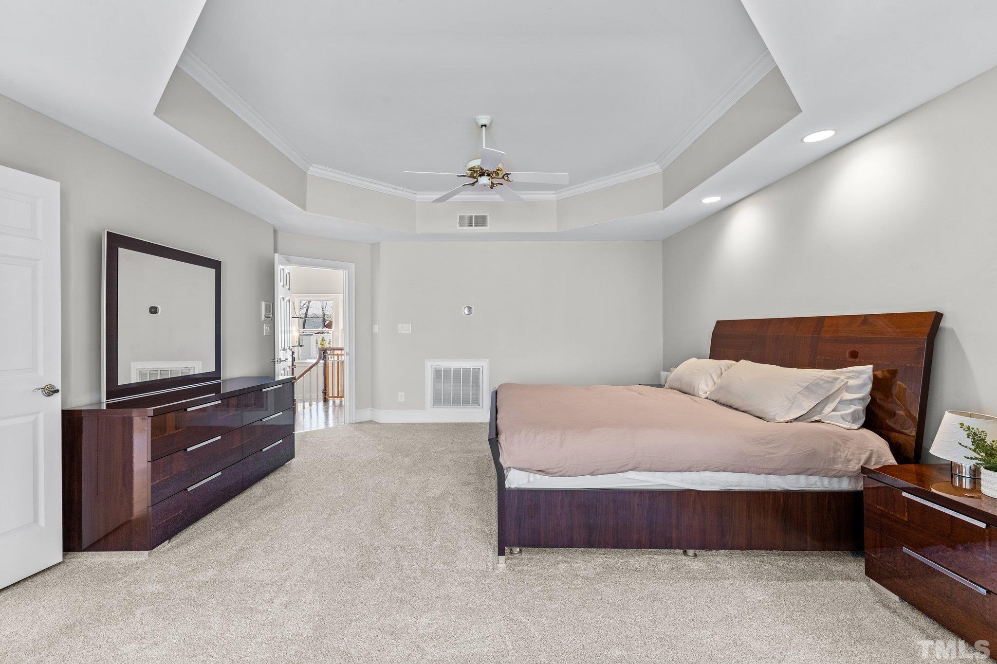 1112 Wagon Ridge Road Raleigh, NC 27614 - Photo 26 of 54 a spacious bedroom with a bed and dresser with mirror