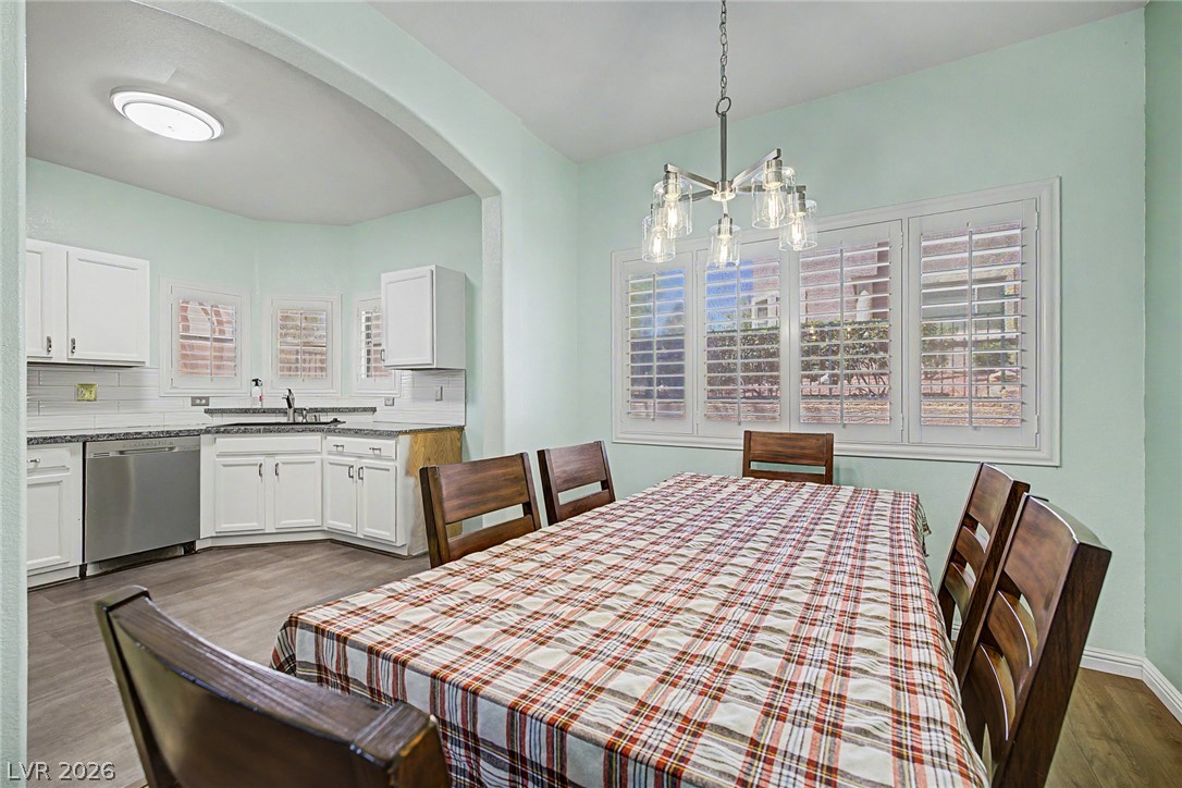 2153 Quarry Ridge Street, Unit 103 Las Vegas, NV 89117 - Photo 2 of 42 Bright dining area with elegant shuttered windows and an adjacent well-appointed kitchen.