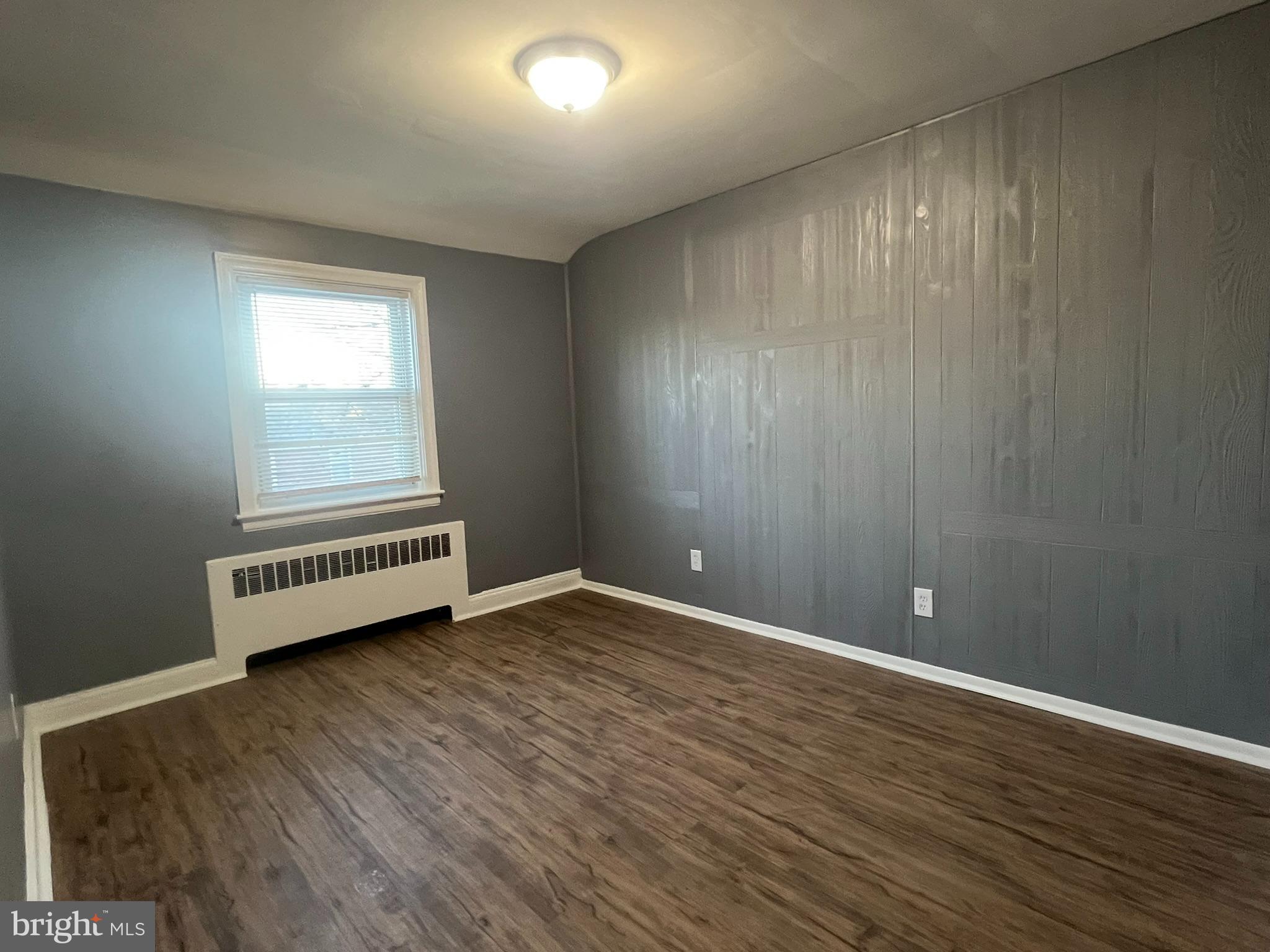 3925 Rexmere Road Baltimore, MD 21218 - Photo 13 of 25 an empty room with wooden floor and windows