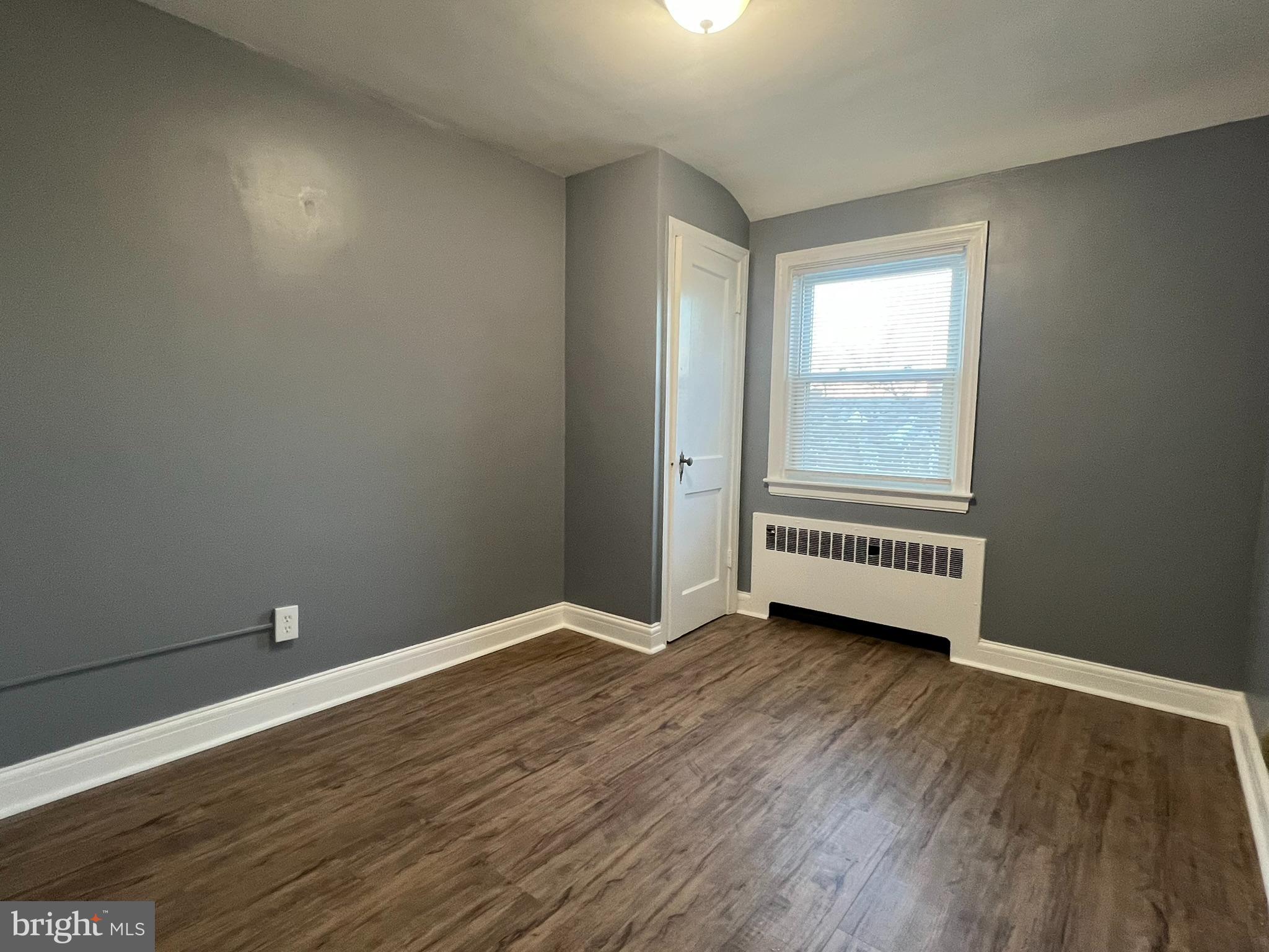 3925 Rexmere Road Baltimore, MD 21218 - Photo 14 of 25 an empty room with wooden floor and windows