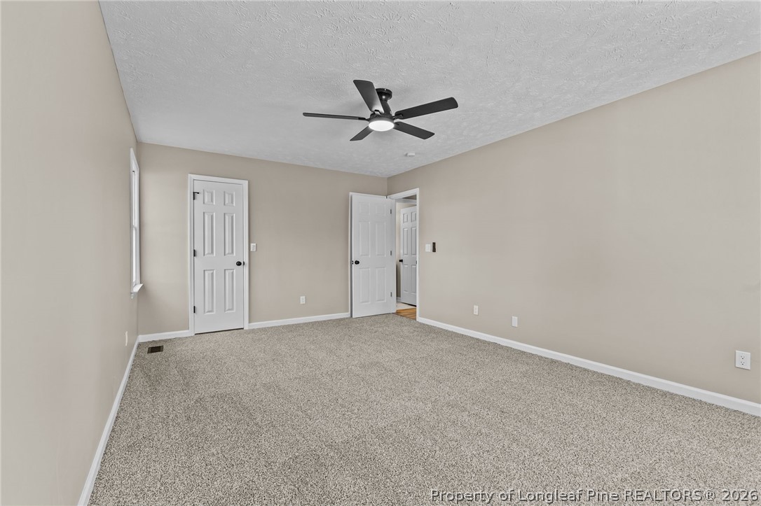 5356 Wade-Stedman Road Wade, NC 28395 - Photo 11 of 38 an empty room with a ceiling fan and a window