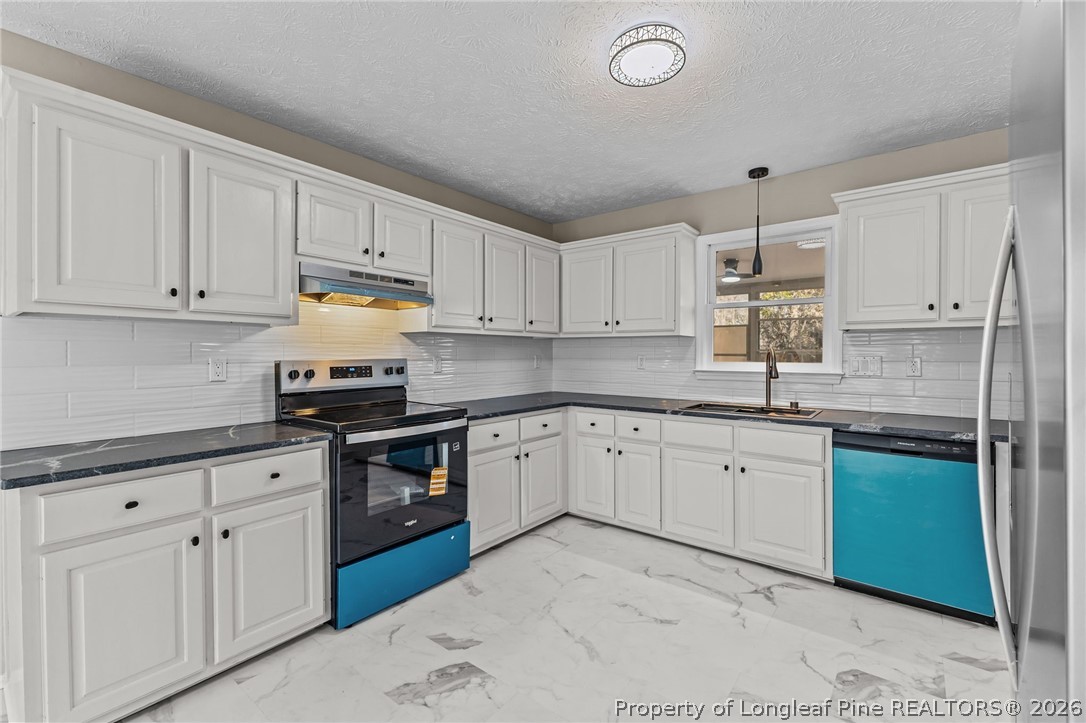 5356 Wade-Stedman Road Wade, NC 28395 - Photo 18 of 38 a kitchen with granite countertop white cabinets white stainless steel appliances with a sink and dishwasher