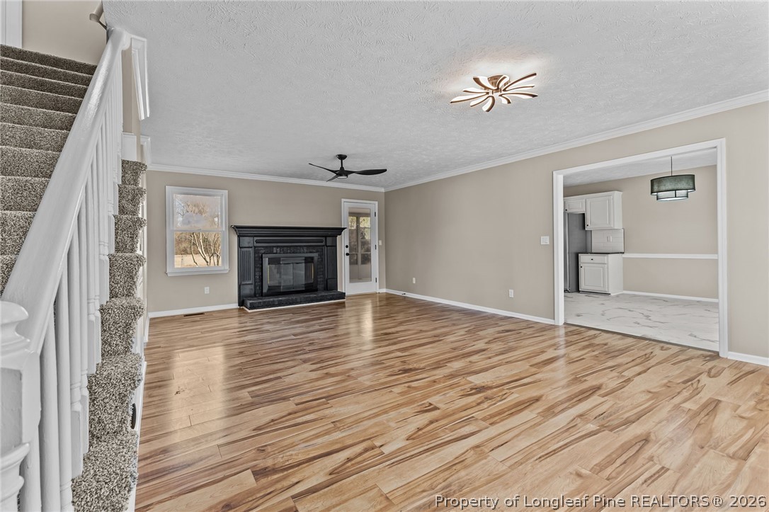 5356 Wade-Stedman Road Wade, NC 28395 - Photo 4 of 38 a view of an empty room with wooden floor fireplace and a window