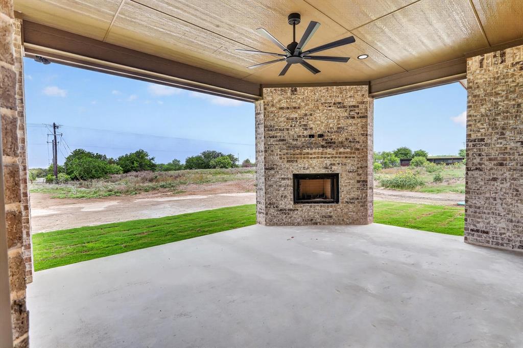 471 Red Bird Drive Springtown, TX 76082 - Photo 33 of 35 Covered outdoor patio featuring a brick fireplace with an integrated firebox, a ceiling fan, recessed lighting, and a concrete floor