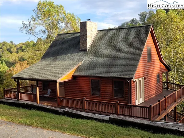 a view of wooden house with a small deck
