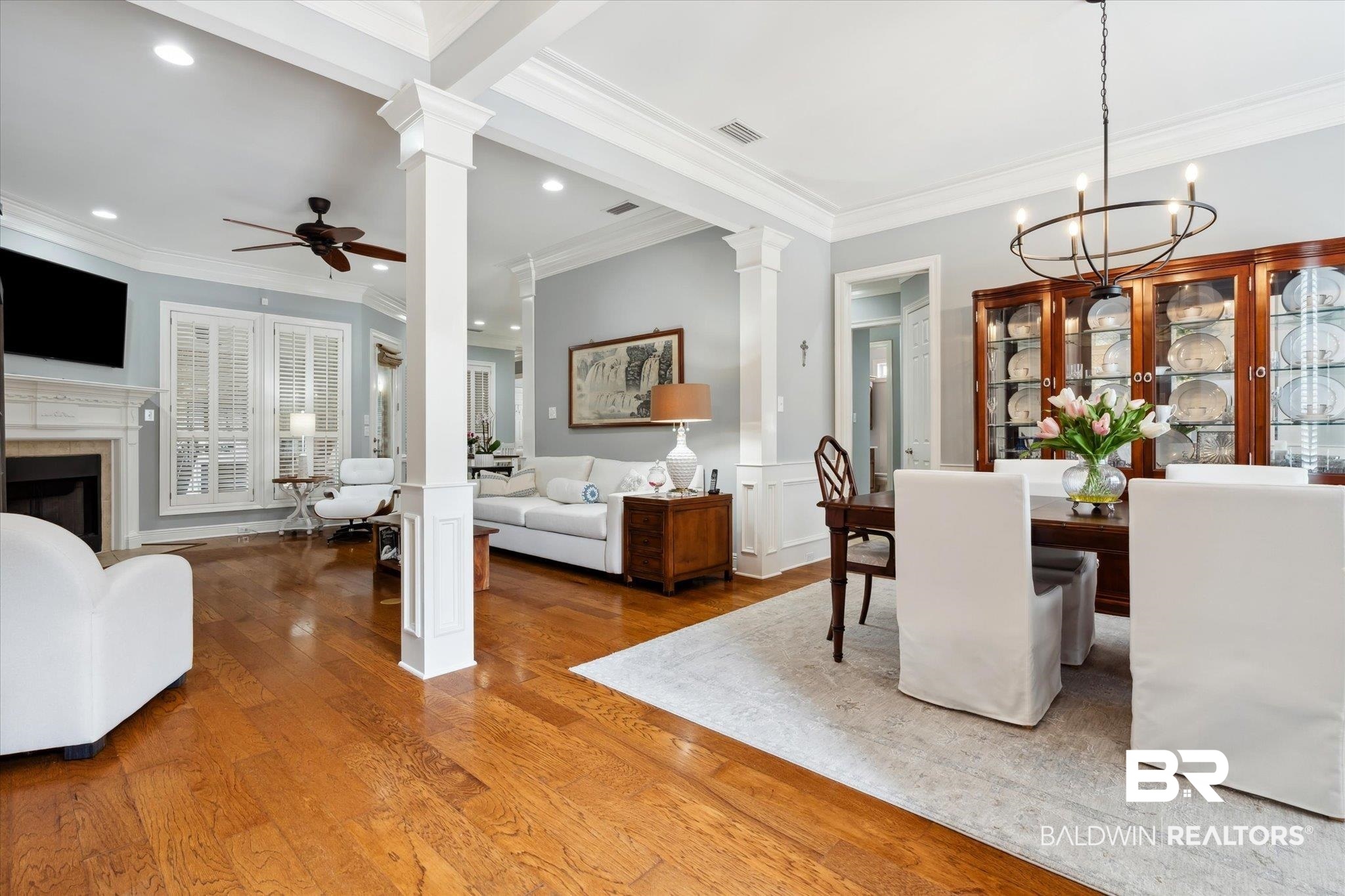 804 Country Club Road Mobile, AL 36609 - Photo 6 of 63 Dining area featuring a premium fireplace, decorative columns, ceiling fan with notable chandelier, hardwood / wood-style flooring, and ornamental molding