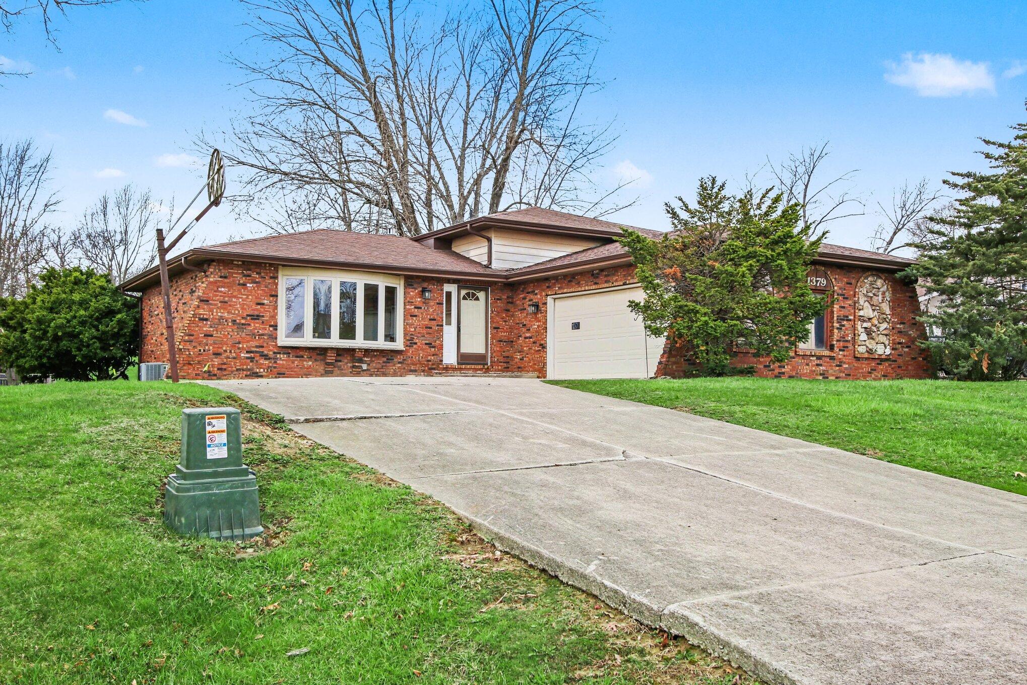 1379 Leeward Road Crown Point, IN 46307 - Photo 1 of 39 a front view of a house with a yard and trees