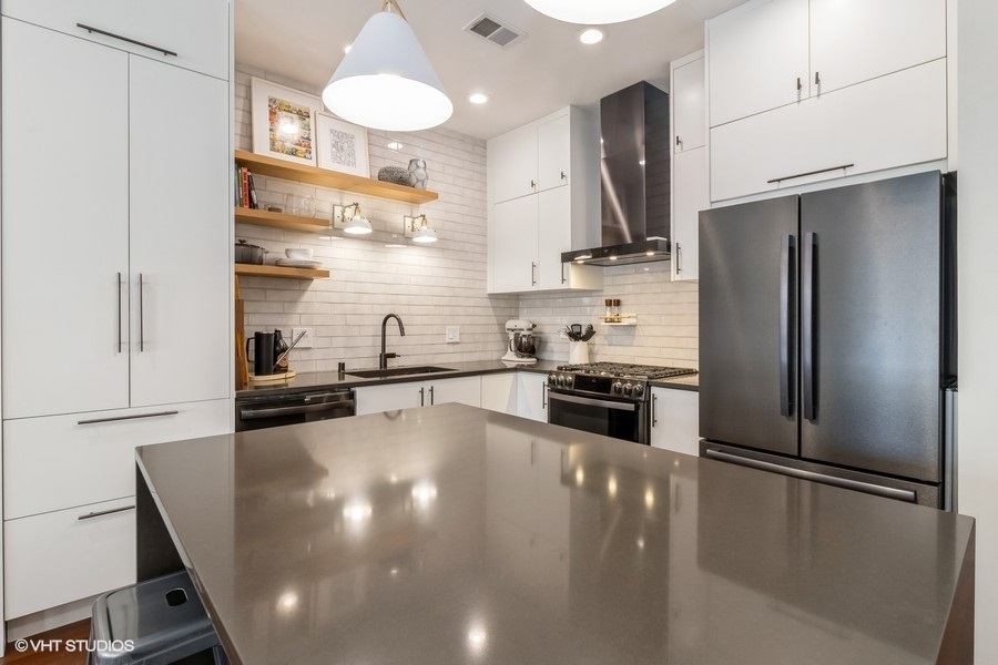 2122 West Rice Street, Unit 4 Chicago, IL 60622 - Photo 5 of 22 a kitchen with stainless steel appliances a refrigerator a sink a stove and white cabinets